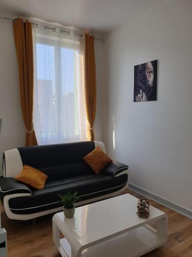 un salon avec un canapé noir et une table dans l'établissement Appartement duplexe de 1 à 4 chambres privées dans maison, à Le Teil