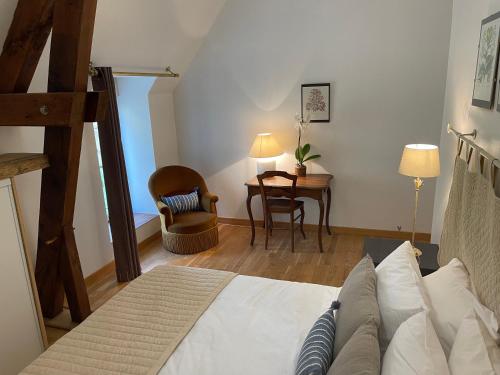 a bedroom with a bed and a table and a chair at Manoir de La Brunie-Grand Longere in Coux-et-Bigaroque