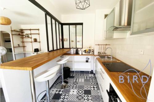 - une cuisine avec des placards blancs et du carrelage noir et blanc dans l'établissement Bright flat near to the beach & harbor, à Saint-Laurent-du-Var