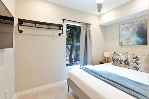Una habitación blanca con una cama y una ventana en Elegant Miami Apartment East Little Havana / Free Parking, en Miami