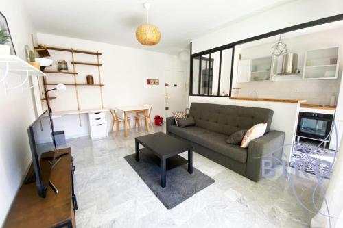 un salon avec un canapé et une table dans l'établissement Bright flat near to the beach & harbor, à Saint-Laurent-du-Var