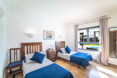 sypialnia z dwoma łóżkami i oknem w obiekcie Villa Lucero w mieście Playa Blanca