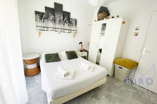 une chambre avec un lit blanc dans une pièce dans l'établissement Bright flat near to the beach & harbor, à Saint-Laurent-du-Var