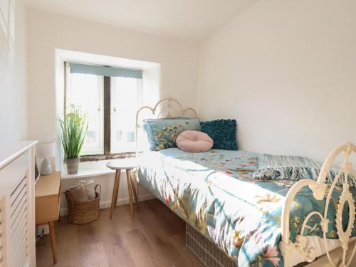 um quarto com uma cama e uma janela em Rose Cottage em Settle