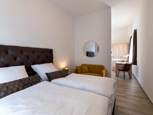 a hotel room with two beds and a couch at GLEUEL INN - digital hotel & serviced apartments & boardinghouse mit voll ausgestatteten Küchen in Hürth