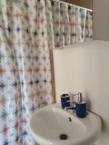 a bathroom with a white sink and a mirror at Cabaña de campo en Pirque in Pirque