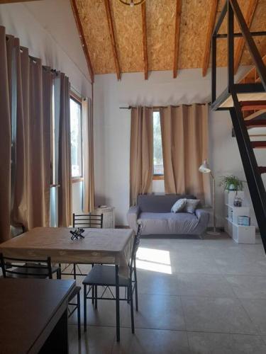 a living room with a table and a bed at Cabaña de campo en Pirque in Pirque