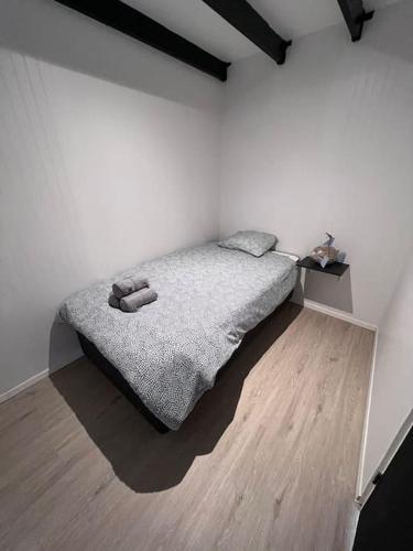 a white bedroom with a bed and a wooden floor at Cabaña Espectacular Maitencillo in Valparaíso