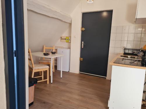 a kitchen with a table and a black door at studio cosy in Vieux-Charmont