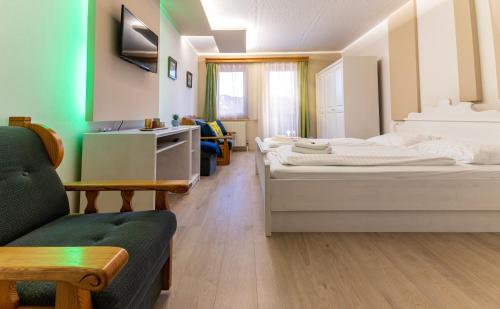 a hotel room with two beds and a couch at Mountain view apartments in Bad Mitterndorf