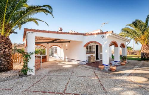ein weißes Haus mit Palmen davor in der Unterkunft Lovely Home In Chiclana De La Fronter in Chiclana de la Frontera