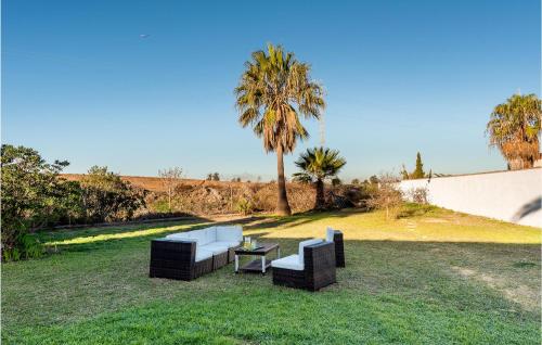 eine Terrasse mit zwei Sofas und einem Tisch im Gras in der Unterkunft Lovely Home In Chiclana De La Fronter in Chiclana de la Frontera