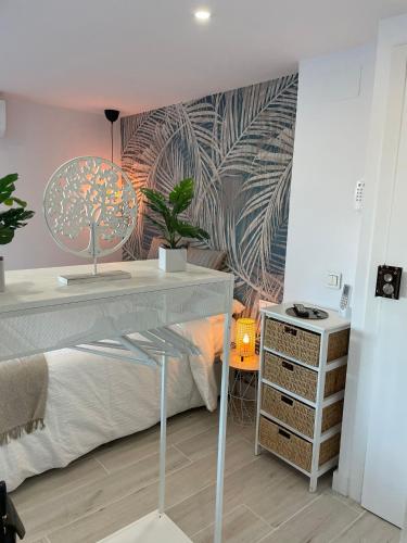 a bedroom with a bed and a desk with a tree mural at Apartamento Tres Banderas in Estepona