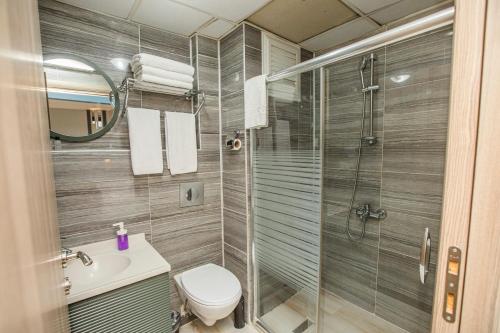 y baño con ducha, aseo y lavamanos. en Konuk Hotel en Eskisehir