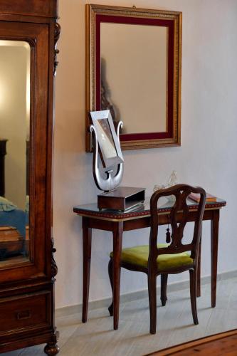 a desk with a mirror and a chair and a lamp at Villa Albaluce in Caluso