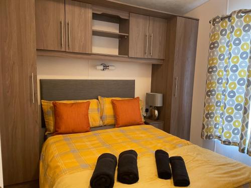 Una cama con dos pares de zapatos encima. en VaLa VistA - Holiday Home On The Beach, en Jaywick Sands