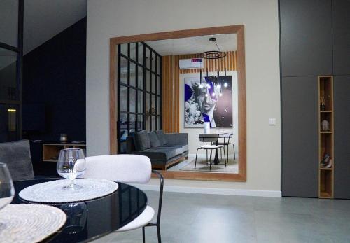 a living room with a table and a mirror at Apart Hotel на Трояндовой in Chernivtsi
