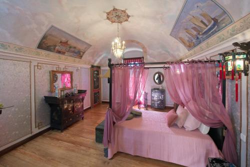 a bedroom with two beds with pink curtains at Villa Albaluce in Caluso
