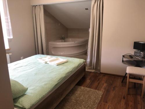 a bedroom with a bed and a bath tub and a sink at Piątka noclegi- Łódź in Łódź