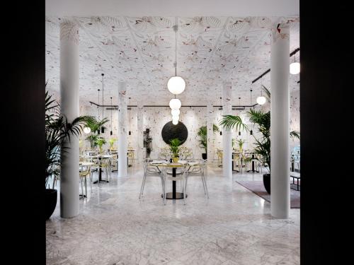 a room with tables and chairs and a ceiling with plants at MABI City Centre in Maastricht
