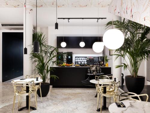 a restaurant with tables and chairs and potted plants at Mabi City Centre Hotel in Maastricht