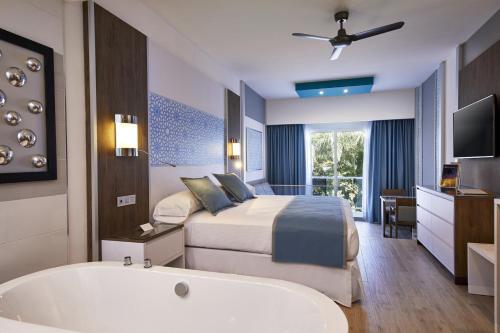 a hotel room with a bed and a bath tub at Riu Palace Riviera Maya - All Inclusive in Playa del Carmen