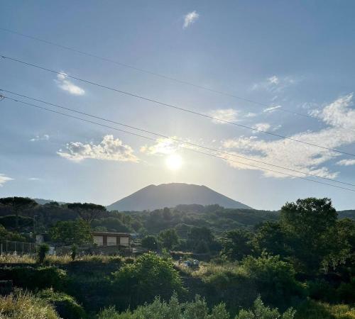 a view of a mountain with the sun in the sky at B&B Iolì Vesuvio in Ercolano