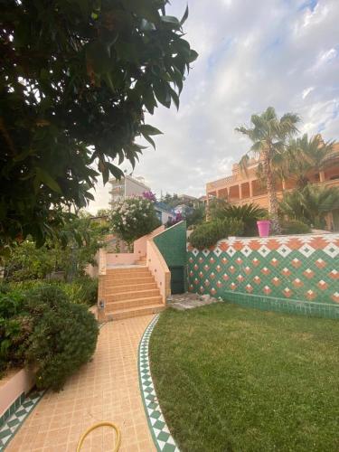 a garden with stairs and a fence and grass at Maroccana in Dobra Voda