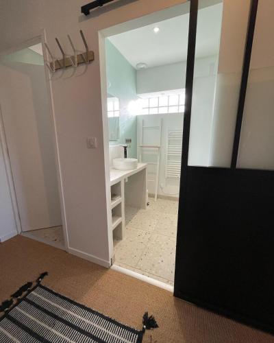 a room with a bathroom with a sink and a mirror at L'Annexe Amiens in Amiens