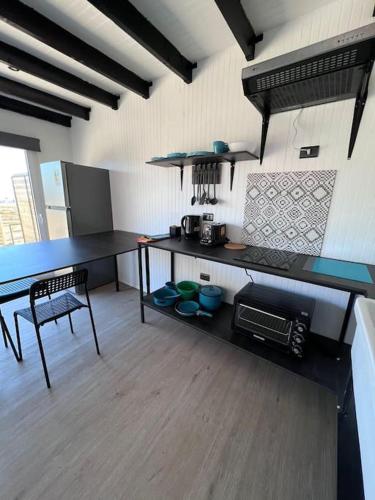 a kitchen with a counter and a table and a chair at Cabaña Hermosa Maitencillo in Valparaíso