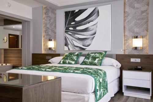 a bedroom with a bed and a painting on the wall at Riu Palace Riviera Maya - All Inclusive in Playa del Carmen