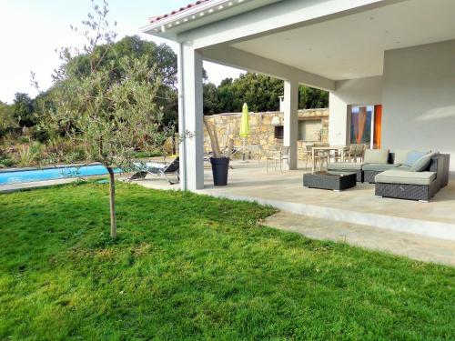 un patio extérieur avec des canapés et une cour dans l'établissement Arinella Villas, à Farinole