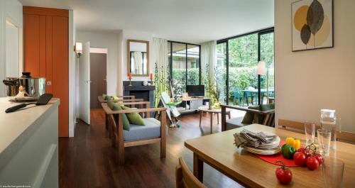 Il comprend une cuisine et un salon avec une table à manger. dans l'établissement Center Parcs Les Bois Francs, à Verneuil-sur-Avre