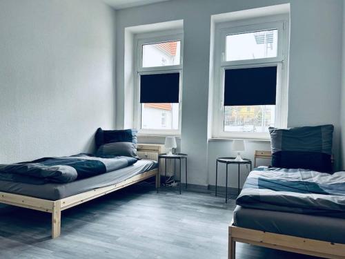 2 Betten in einem Zimmer mit 2 Fenstern in der Unterkunft cozy Monteurwohnung/WLAN in Bautzen