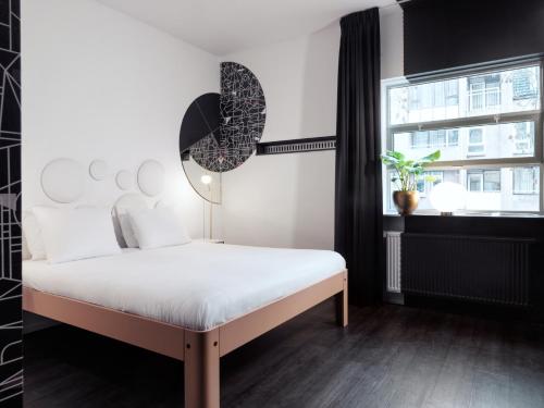 a bedroom with a white bed and a window at MABI City Centre in Maastricht