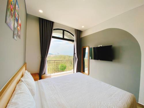 a bedroom with a white bed and a window at The Sol House in Phu Quoc