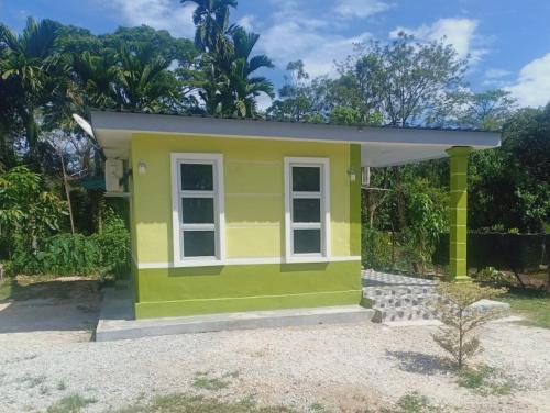 una casa pequeña con un exterior amarillo y verde en Inap Desa 3, 