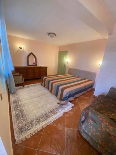 a bedroom with two beds and a couch and a mirror at Maroccana in Dobra Voda