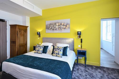 a bedroom with a large bed with yellow walls at Belle Normandy in Bayeux