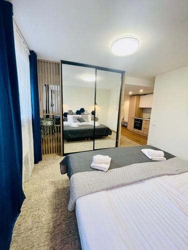 a bedroom with two beds and a large mirror at Alanta Apartments Easy Kaunas in Kaunas