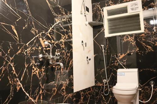 a bathroom with a toilet and a air conditioner on the wall at Taniva Dani by CoffeeBeanVilla in Sakleshpur