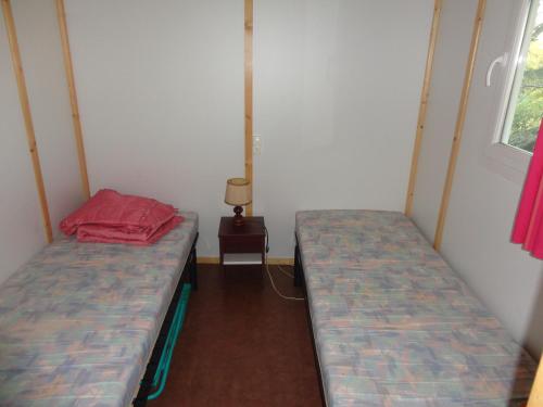 Zimmer mit 2 Betten und einem Tisch mit einer Lampe in der Unterkunft clos du celine in Castillonnès