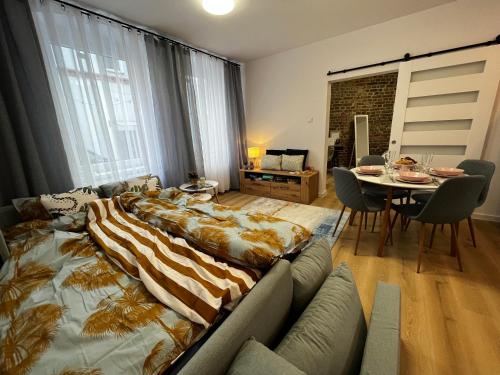 ein großes Bett im Wohnzimmer mit einem Tisch in der Unterkunft Comfortable apartment for 1-4 guests in Chorzów