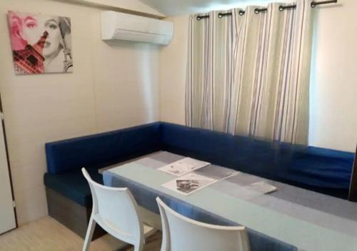 Cette petite chambre comprend une table bleue et des chaises. dans l'établissement La Roque d'Anthéron - Mobile-home - 6 pers - 3 ch - Piscine, à La Roque-dʼAnthéron