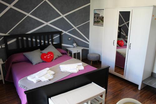 een slaapkamer met een bed met handdoeken en een spiegel bij B&B Momentidì in Paestum