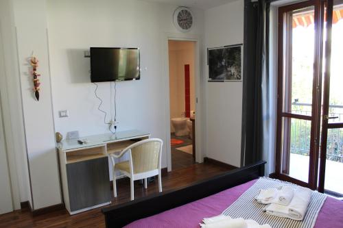 Schlafzimmer mit einem Bett, einem Schreibtisch und einem TV in der Unterkunft B&B Momentidì in Paestum