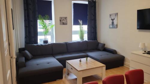 - un salon avec un canapé bleu et une table dans l'établissement Stadtnah an der Förde 75 1, à Flensbourg