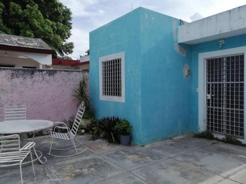 a table and chairs in front of a blue building at Villa Los Arcos, Zazil Há in Mérida