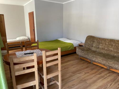 ヴィスワにあるWilla DINAのテーブル、ベッド、ソファが備わる客室です。