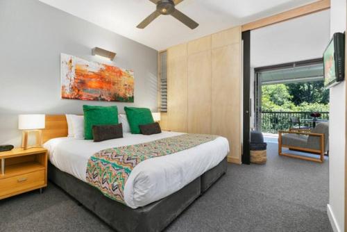 a bedroom with a large bed with green pillows at 9408 Luxury Apartment Close to Hastings Street in Noosa Heads